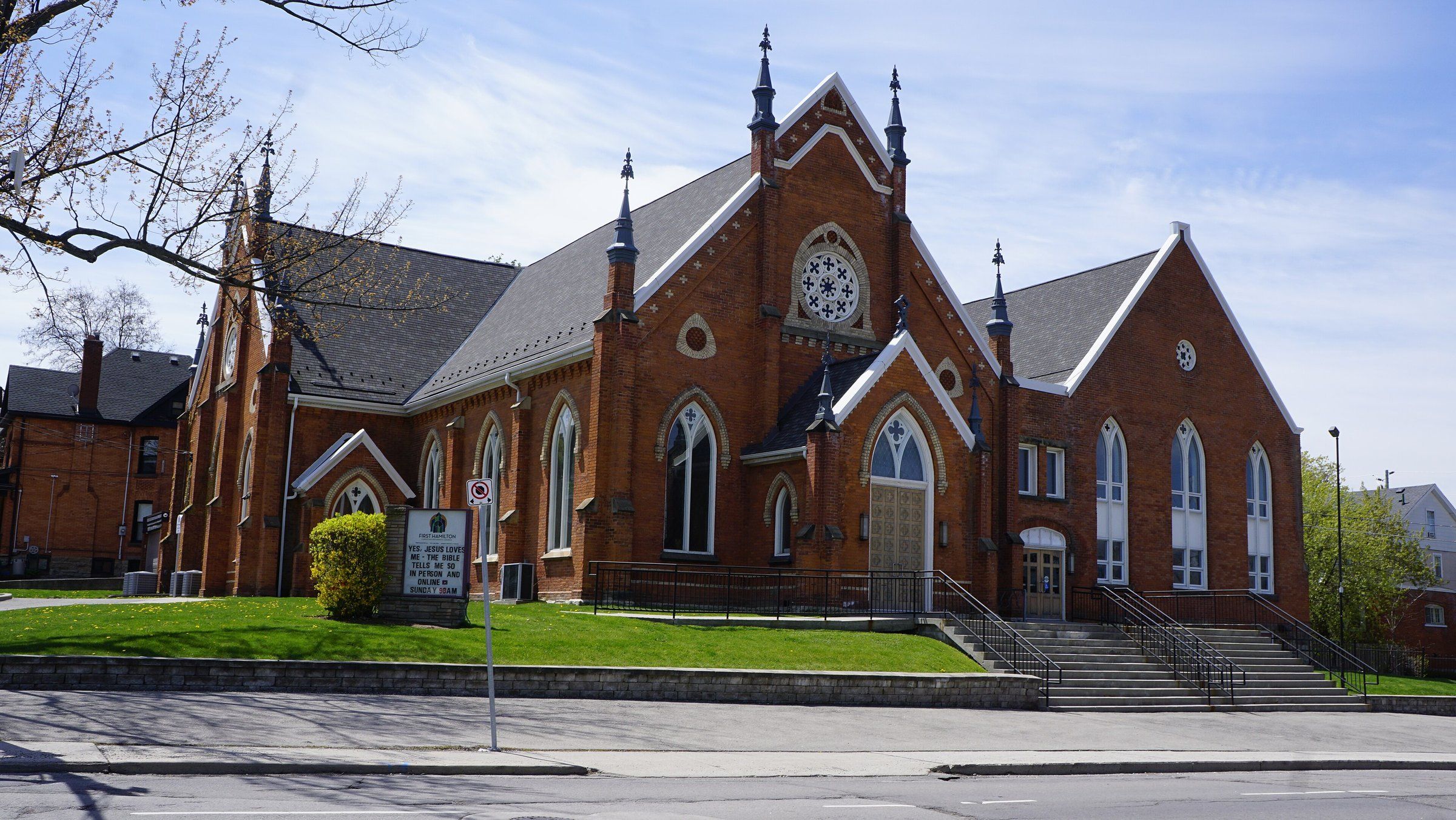 First Hamilton Christian Reformed Church on Charlton Avenue West, where Blessings is worshipping for now: a red-brick Gothic Revival church with pinnacles on its gables, a rose window and pointed windows trimmed in pale brick, above a lawn and wide steps